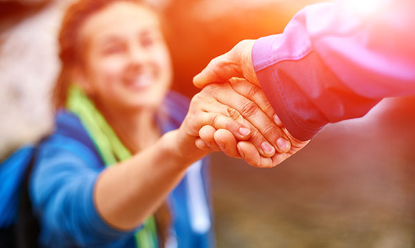 Woman grabs a hand with a pink light surrounding it
