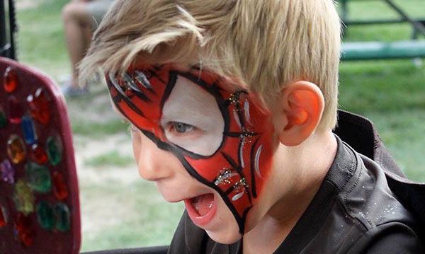 Little boy showing off spiderman face paint