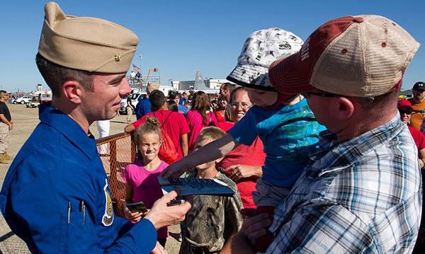Soldier showing child a piece of military equipment