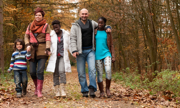 Two adults and three kids walking down a path