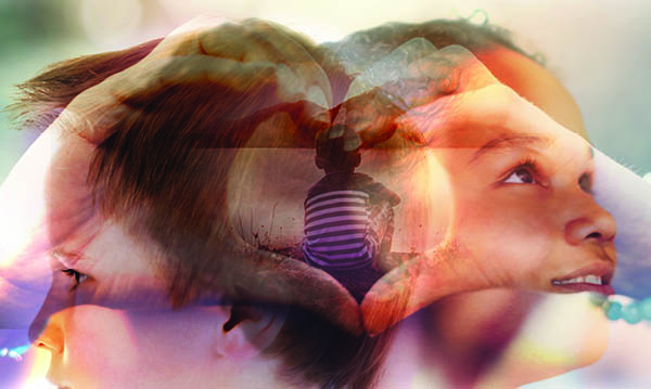 Whimsical photo of smiling kids fading behind heart hands