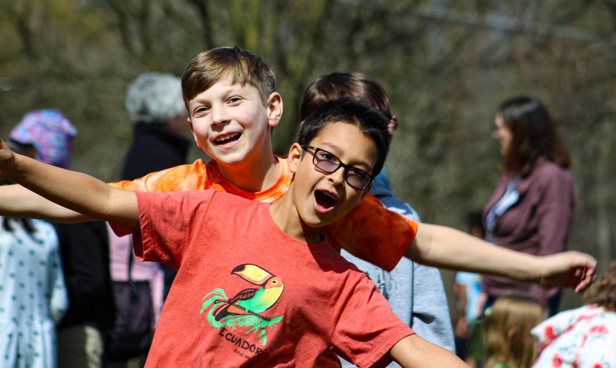 Students at The Roeper School enjoying outdoor activities and smiling with friends on a sunny day.