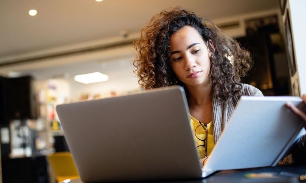High school student studying with a laptop and notes, preparing for the digital SAT. Parents in metro Detroit can explore local SAT prep and tutoring options.