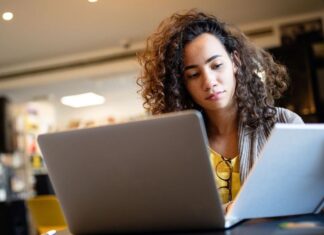 High school student studying with a laptop and notes, preparing for the digital SAT. Parents in metro Detroit can explore local SAT prep and tutoring options.