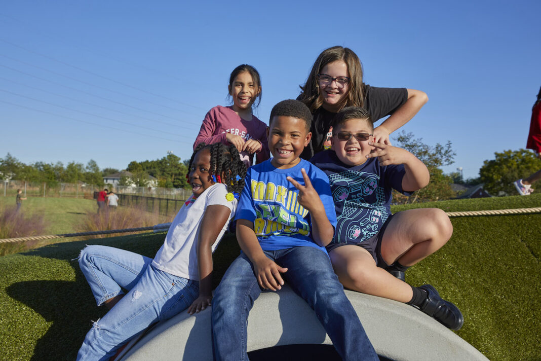 summer-fun-champ-camps-kids-piled-up-on-playground-with-big-smiles