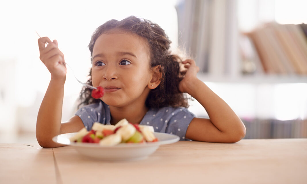 does-your-child-eat-enough-fruit-young-girl-eating-a-bowl-of-fruit