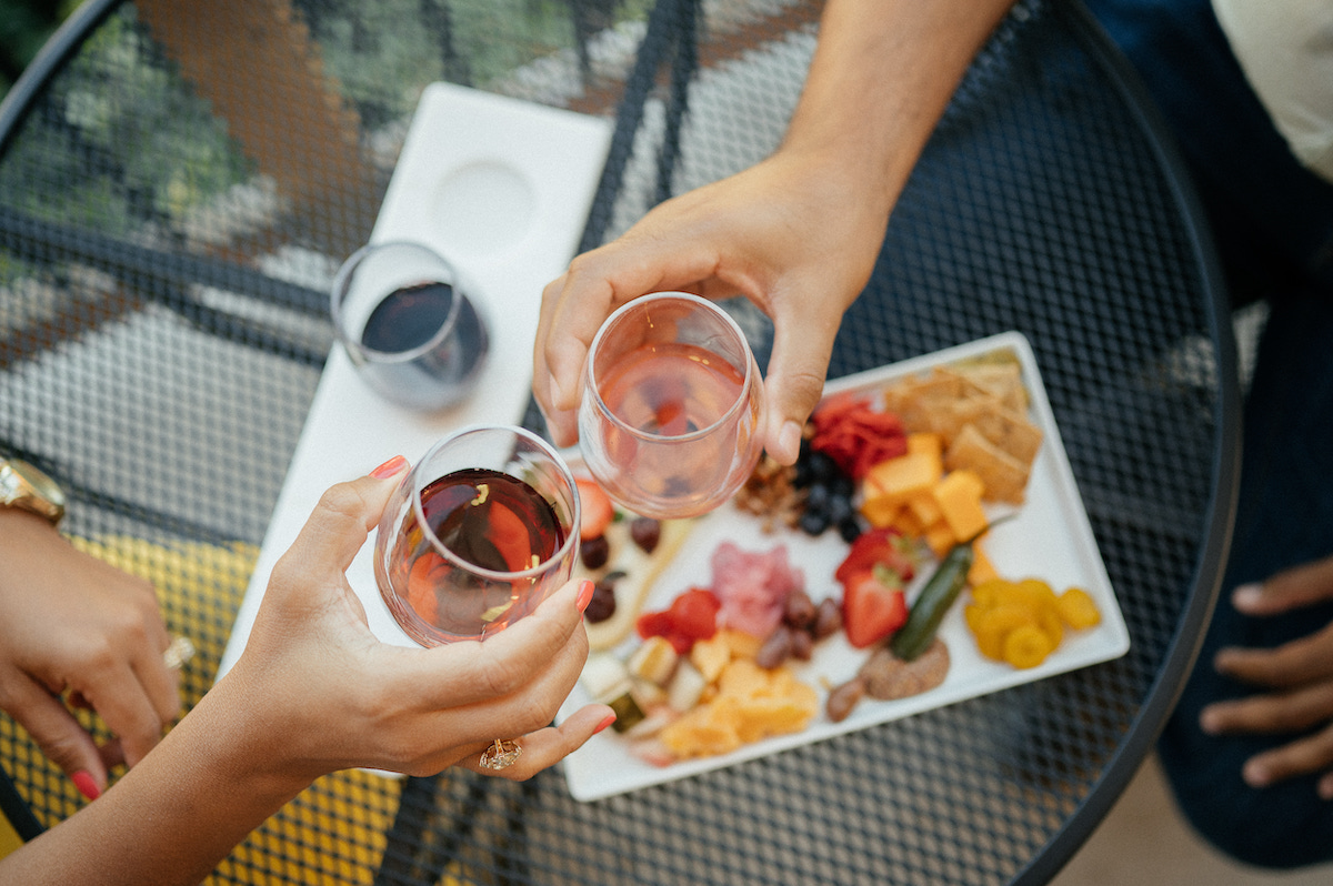 northern-michigan-wine-tour-clinking-glasses-above-charcuterie-board
