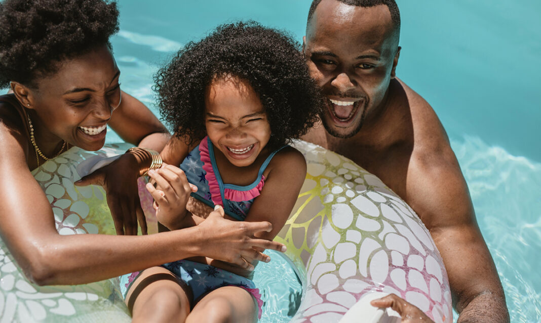 summer-vacation-tips-for-autism-families-mom-dad-and-daughter-enjoying-the-pool-on-summer-vacation