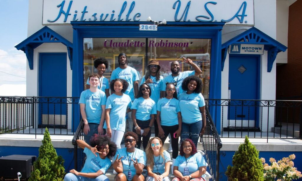 Group of students and counselors wearing blue Hitsville NEXT t-shirts posing on the steps of the iconic Hitsville U.S.A. building, home to the Motown Museum, during the Hitsville NEXT Summer Camps.