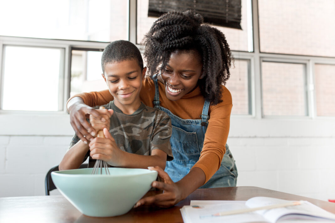 mom-helping-pre-teen-in-kitchen-stir-batter