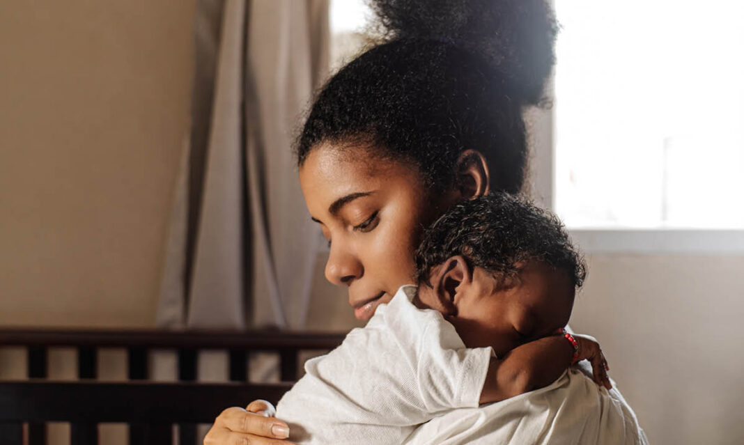 Mother holding newborn baby weeks after giving birth