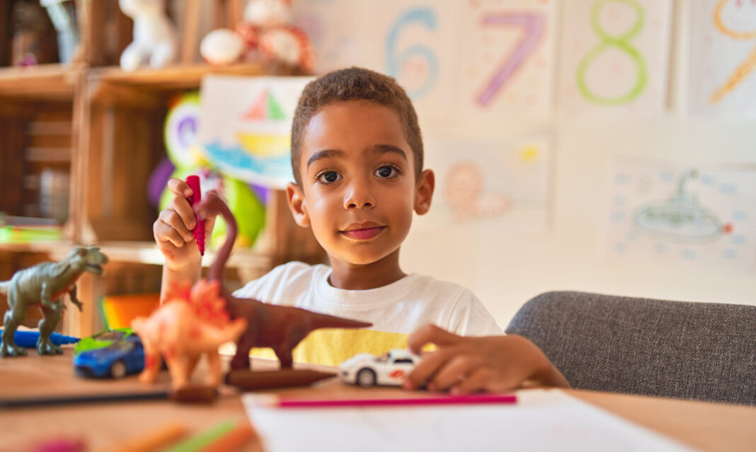 Young boy playing with his toys as part of his ABA therapy