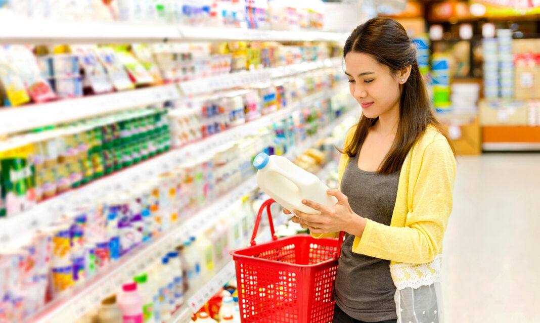 Woman buying milk at the groceries store