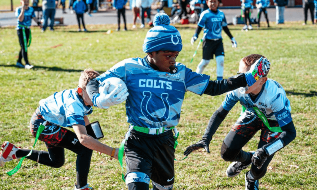 a photo of football guy players wearing blue clothes playing flag football in metro Detroit