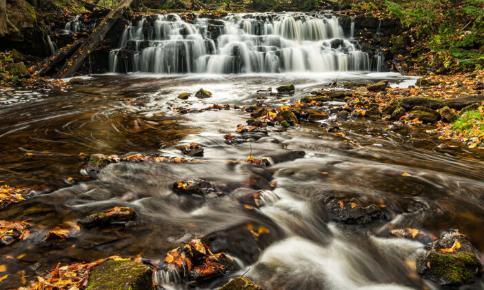 Chapel River with Waterfall, Pictured Rocks National Lakeshore, near Grand Marais, Michigan. Autumn color leaves near the stream which is moving slowly
