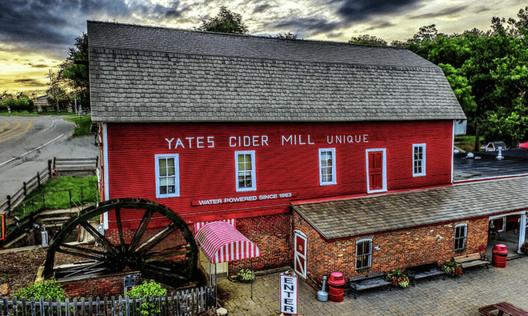 a photo of a barn-like structured house with windows beside a highway