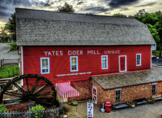 a photo of a barn-like structured house with windows beside a highway
