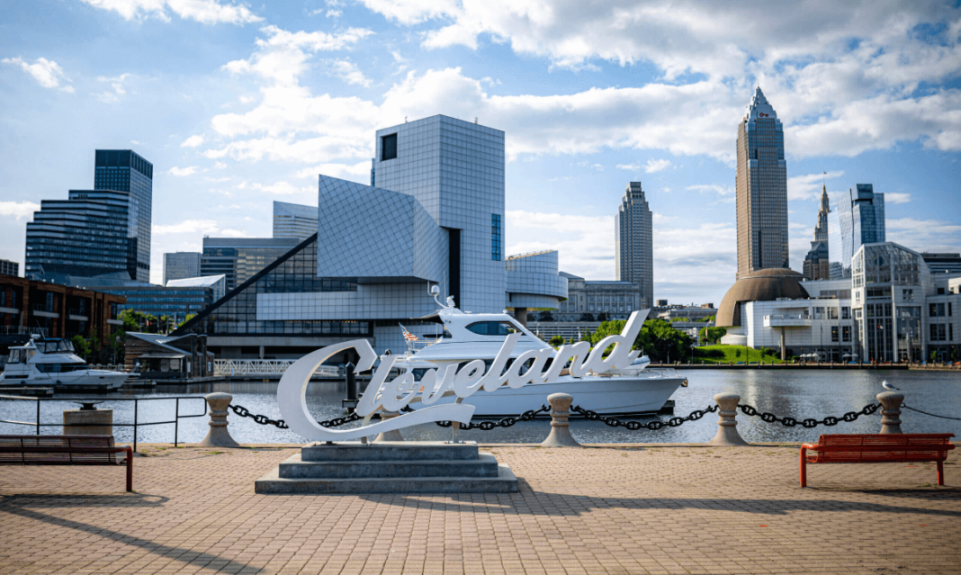 a photo of tall buildings, and river with a Cleveland Sign in Cleveland