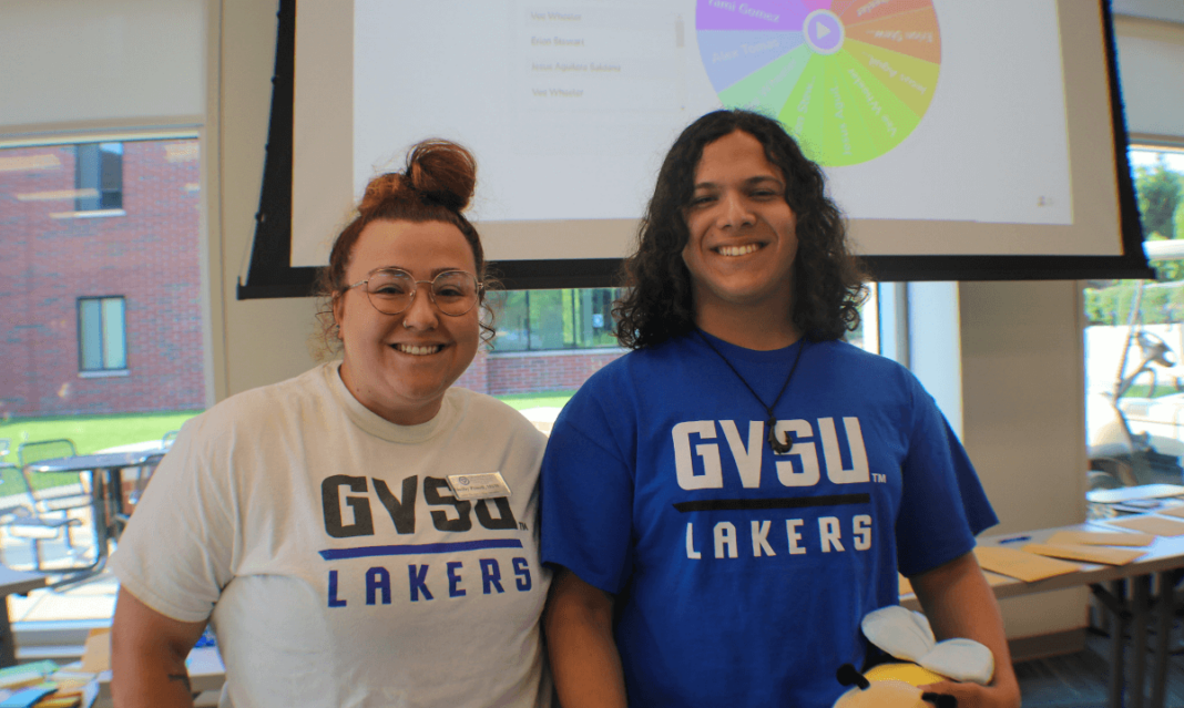 Two smiling college students wearing GVSU Lakers shirts stand in a classroom setting, representing a college readiness program aimed at preparing high school students for academic success.
