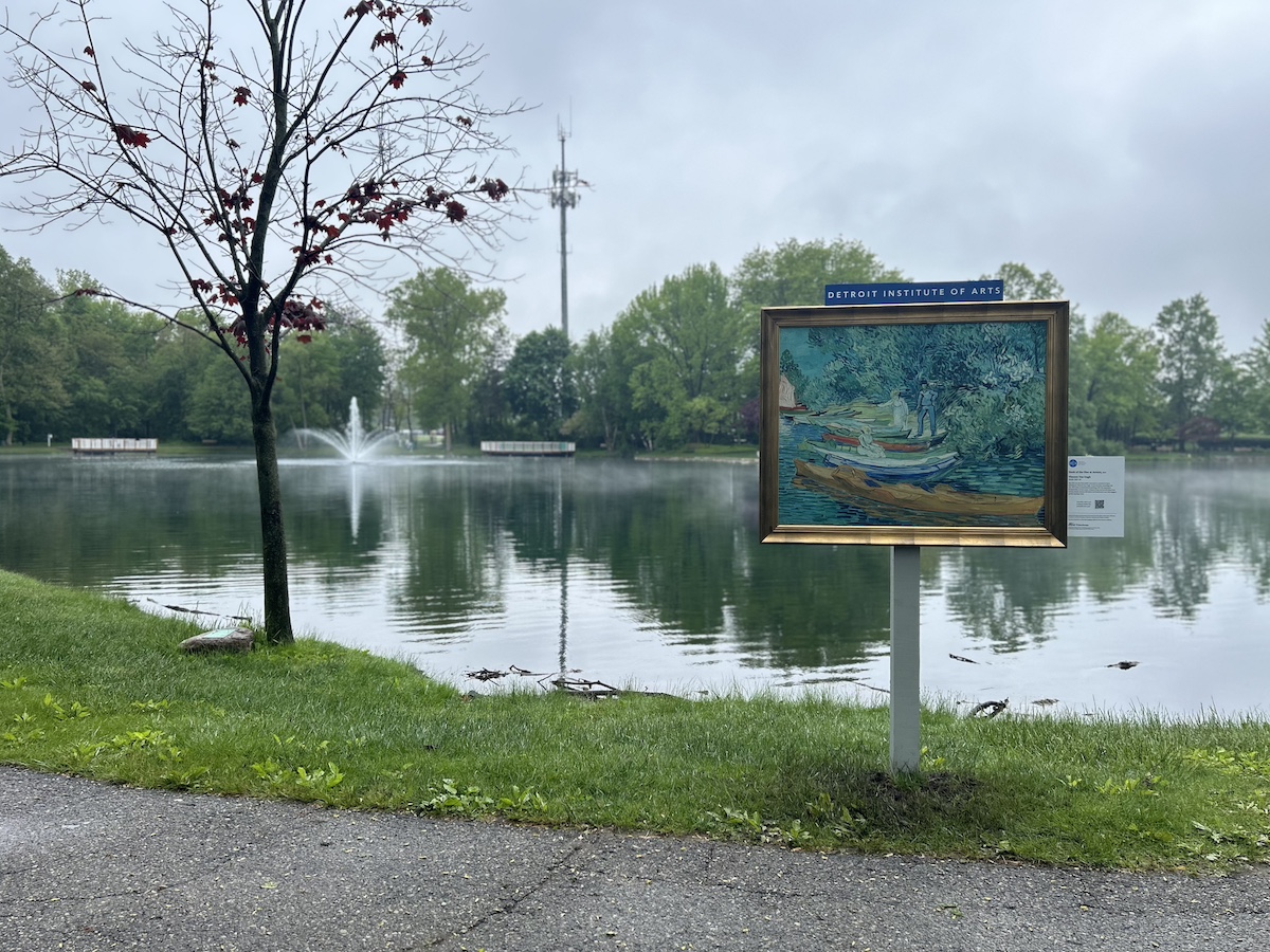 Framed Detroit Institute of Arts painting displayed by the lake at Heritage Lake Loop in Shelby Township, part of the InsideOut Macomb County public art program.