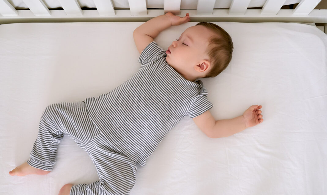 A peaceful baby sleeping soundly, nestled in soft bedding, with a gentle expression on their face and a cozy blanket draped over them