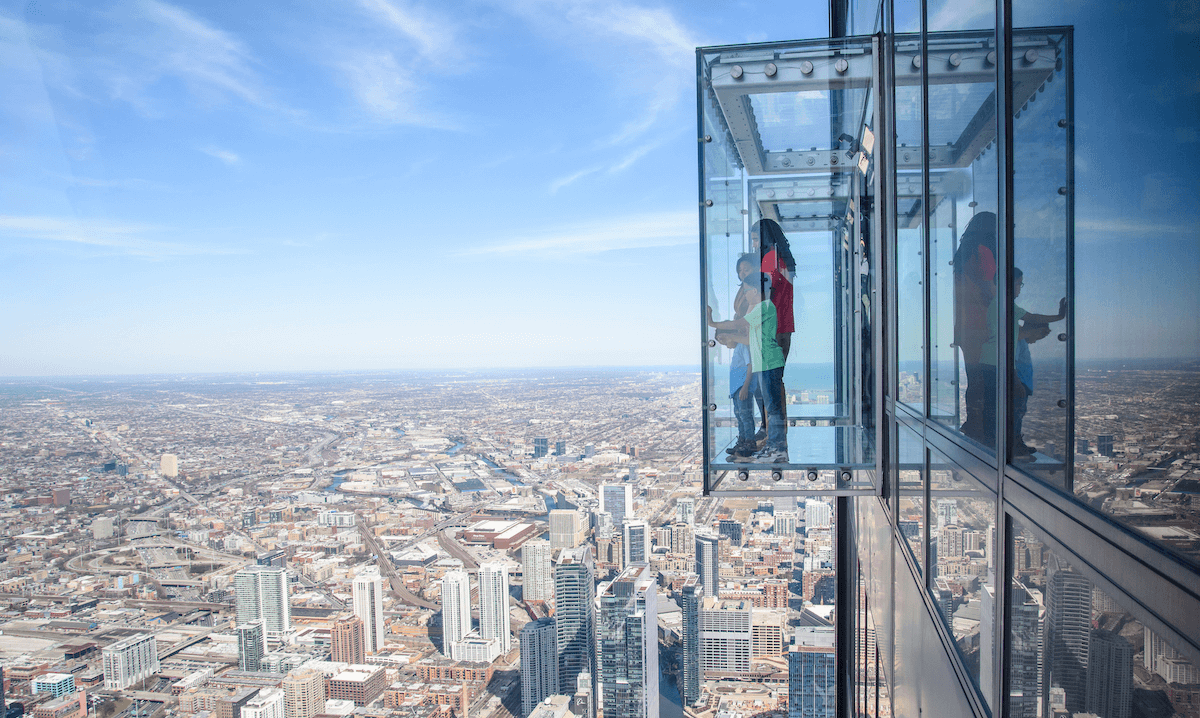 Family enjoying the Skydeck Chicago glass ledge, a thrilling spring break destination near Detroit with panoramic city views