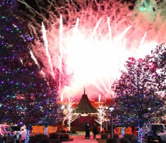 Fireworks light up the sky during Light the Village at The Village of Rochester Hills surrounded by glowing holiday lights.