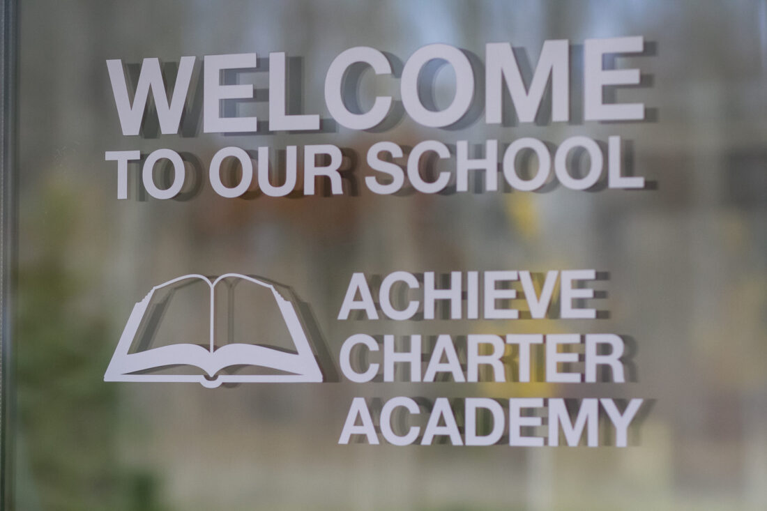 The welcome sign at Achieve Charter Academy, emphasizing a supportive learning environment and scholarship programs.
