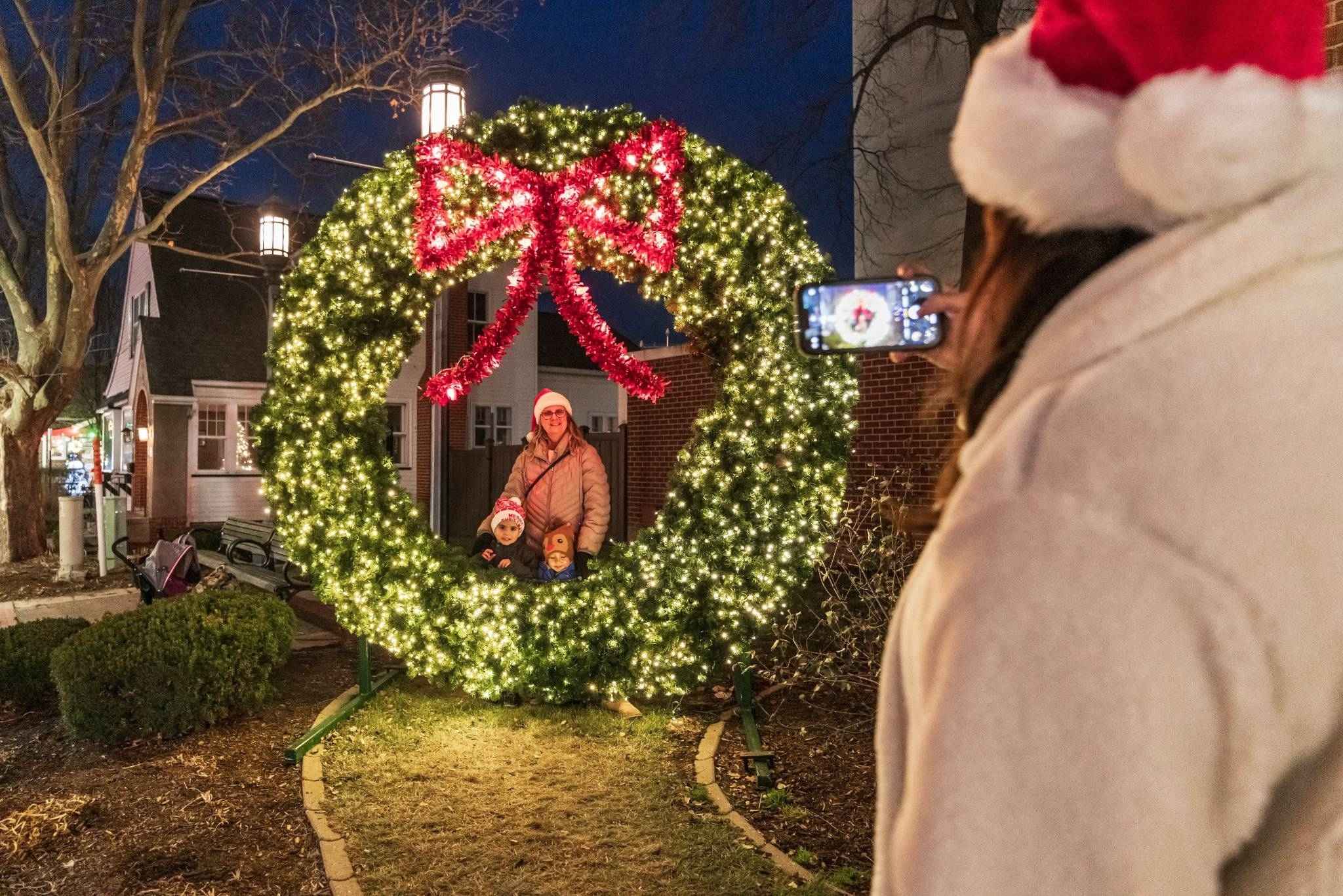 A family poses inside a large lighted wreath during Frankenmuth’s Stop and Snap Challenge in Michigan’s popular Christmas town.