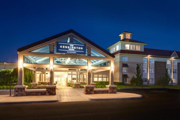 The Kensington Hotel in Ann Arbor, lit up at night, offering a welcoming and family-friendly lodging option for visitors to the area.