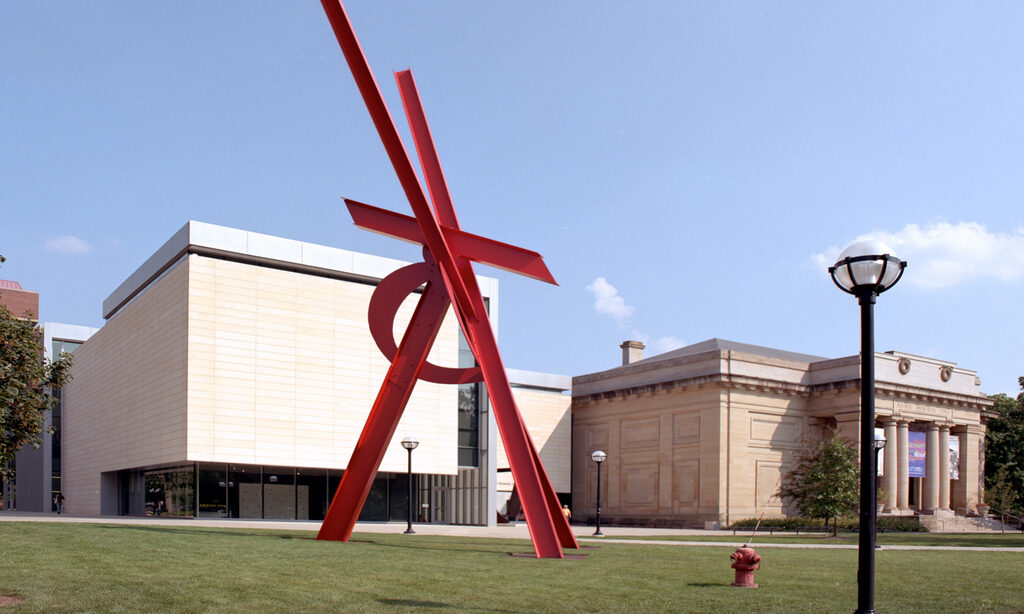 A view of the University of Michigan Museum of Art with its striking outdoor red sculpture and neoclassical building, offering engaging exhibits for family-friendly exploration.