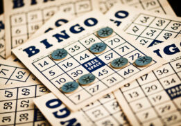 A collection of vintage bingo cards with blue tokens placed on numbers, including the free space, creating a nostalgic game-night atmosphere.