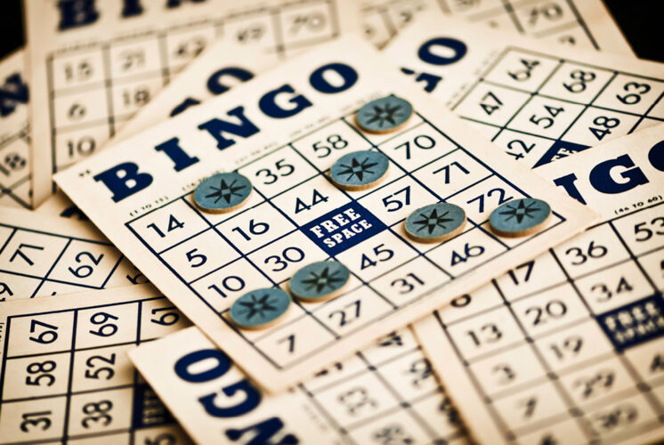 A collection of vintage bingo cards with blue tokens placed on numbers, including the free space, creating a nostalgic game-night atmosphere.