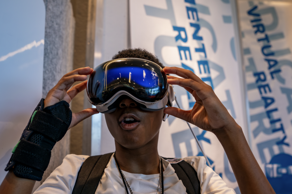 A student at a charter public school experiencing virtual reality with VR goggles, showcasing hands-on learning opportunities in technology and innovation.