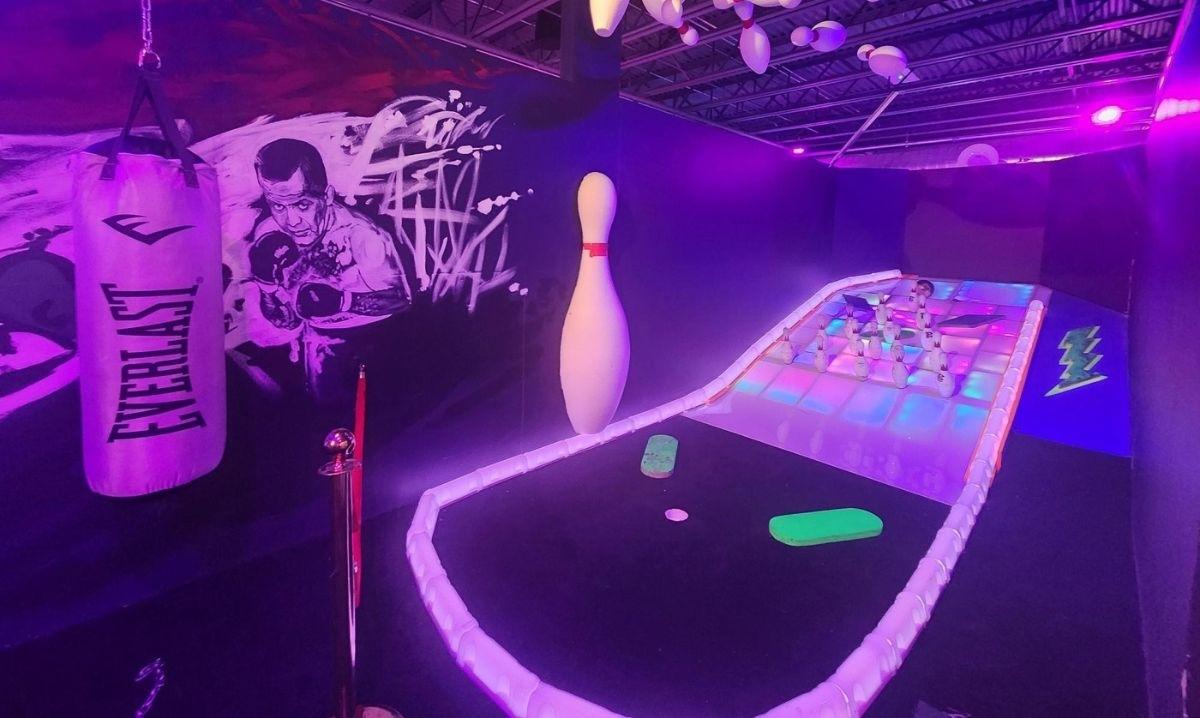 Bowling-themed neon mini golf hole at BIG Best in Games in metro Detroit featuring glowing lights and creative decorations.