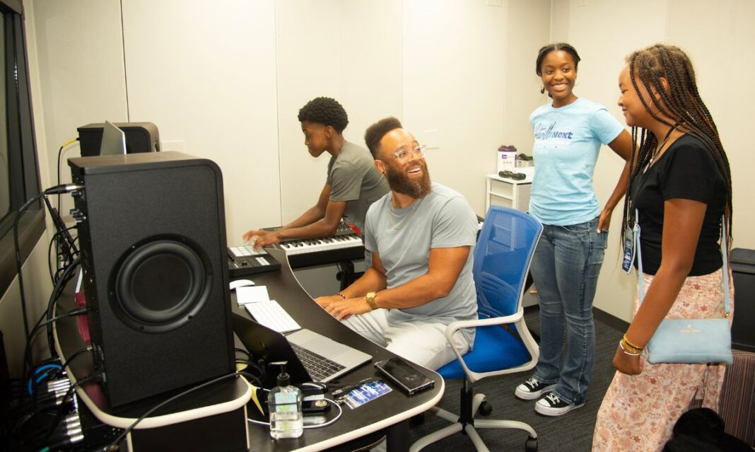 Teens engage in a hands-on music production session at Hitsville NEXT Summer Camps at the Motown Museum. The program offers aspiring musicians opportunities to learn songwriting, production, and performance in a creative, collaborative setting.