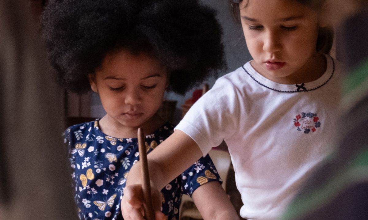 Two young children engage in a hands-on learning activity at Detroit Waldorf School, fostering creativity and collaboration in an interactive classroom setting.