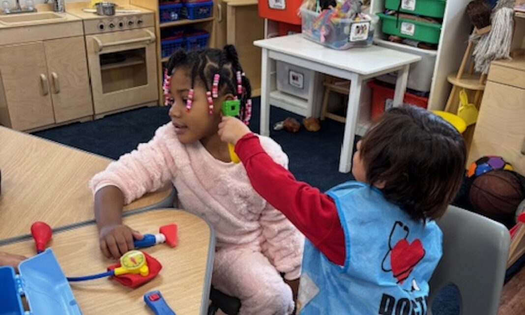 Preschool students engaged in imaginative play at an elementary school in Romulus, developing social and problem-solving skills.