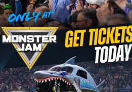 Monster Jam truck Megalodon jumps during a live show at Ford Field in Detroit with fans cheering for the family event.