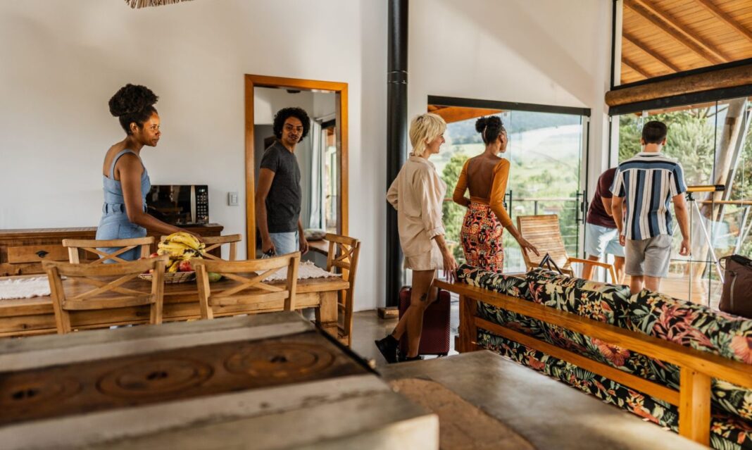 A group of friends arriving at an Airbnb vacation rental with spacious interiors and scenic views, ideal for choosing the right group accommodation.