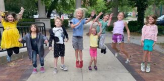 Excited kids jumping in the air at Art Explorers Summer Camp at Riverside Arts Center, with 'Art Camp!' written in colorful chalk on the sidewalk. A fun and creative summer camp experience for children.