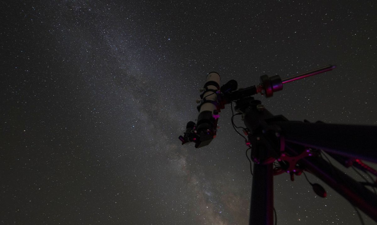 A telescope pointed towards the Milky Way in the night sky at Hocking Hills, Ohio, offering a breathtaking stargazing experience in a dark sky park.