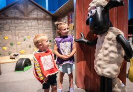 Two young kids interact with a Shaun the Sheep figure at The Henry Ford’s Wallace & Gromit: Get Cracking! exhibit, part of the new spring exhibits in metro Detroit.