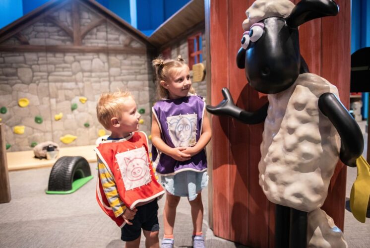 Two young kids interact with a Shaun the Sheep figure at The Henry Ford’s Wallace & Gromit: Get Cracking! exhibit, part of the new spring exhibits in metro Detroit.