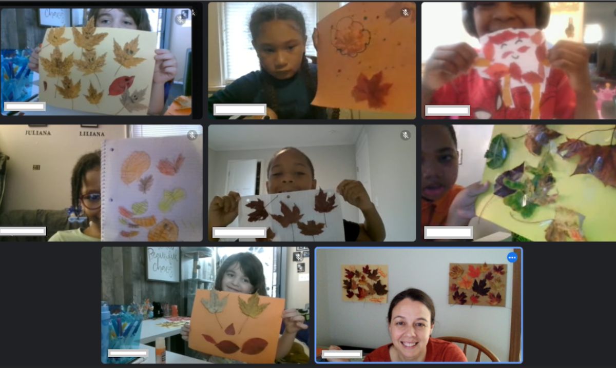 Elementary students in an online public school in Michigan showing their fall-themed leaf art projects during a virtual classroom session with their teacher.