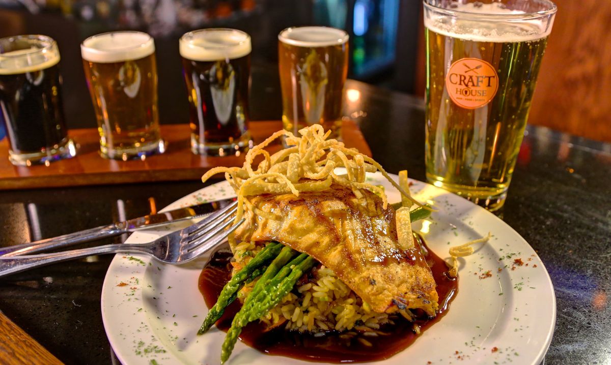 Gourmet grilled salmon over rice and asparagus paired with a craft beer flight at a local brewpub near Indiana Dunes National Park.