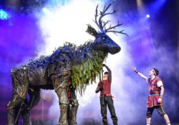 Performers interacting with a towering forest creature puppet during the Dragons & Mythical Beasts live show, a magical theater experience for families and kids
