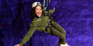 Smiling child on an indoor zipline experience, part of Louisville Kentucky family adventures.