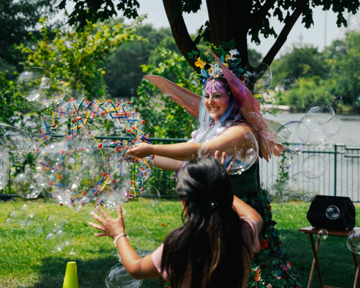 The Book Fairy entertains children with bubbles at a summer bubble dance party at Orion Township Library, a fun and interactive Metro Detroit library event for kids.