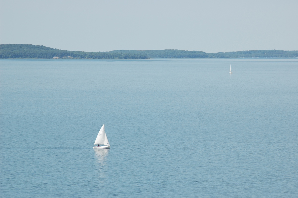 Scenic view of sailboats on Grand Traverse Bay near popular family restaurants in Traverse City, offering waterfront dining experiences.